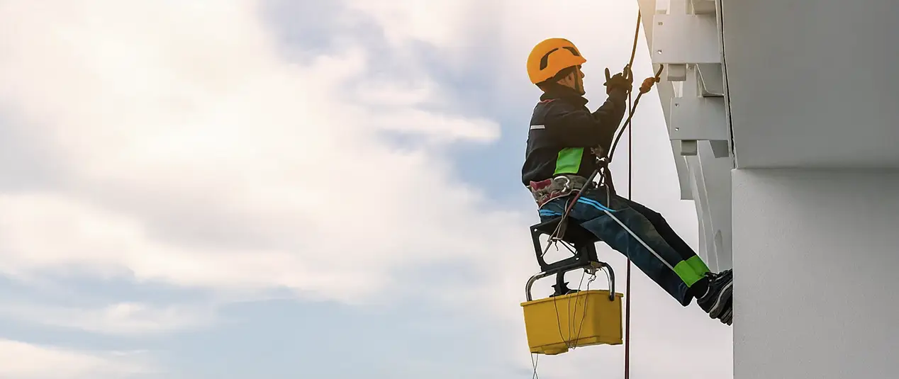 Trabajador en altyra con arnes<br />
